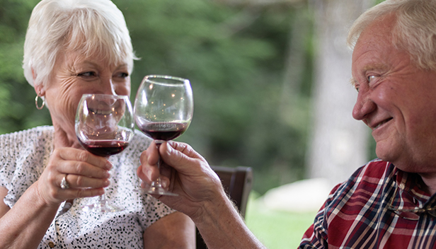 Older couple clinking wine glasses
