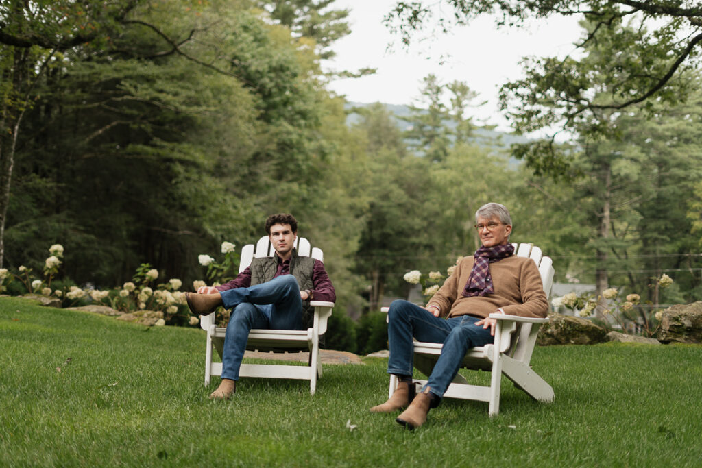 Two men relaxing in Adirondack chairs on the lawn