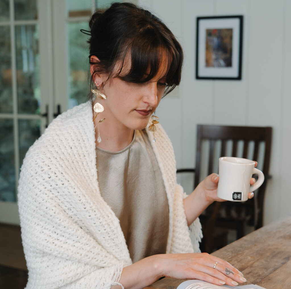 A guest holding a coffee mug at the dining table