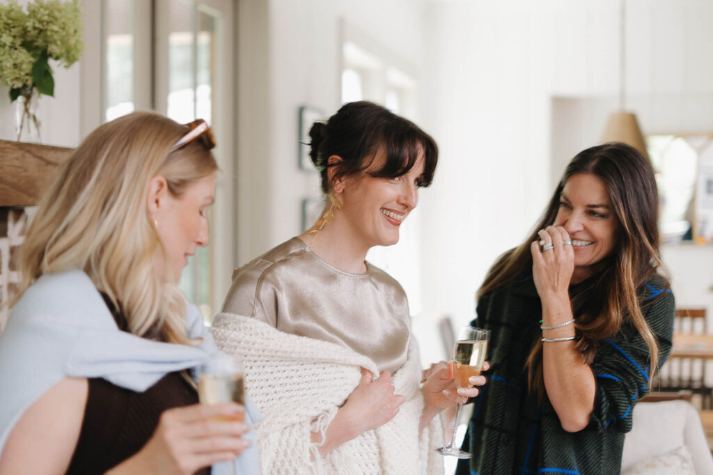Three friends laughing together before a celebration