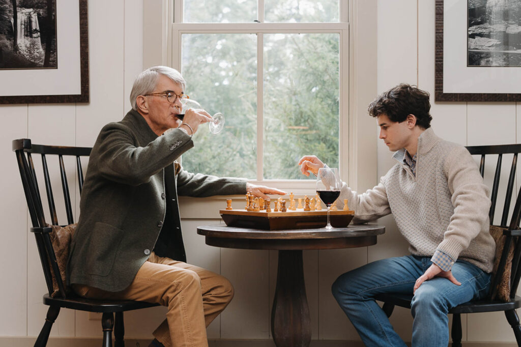 Two guests playing chess by a window