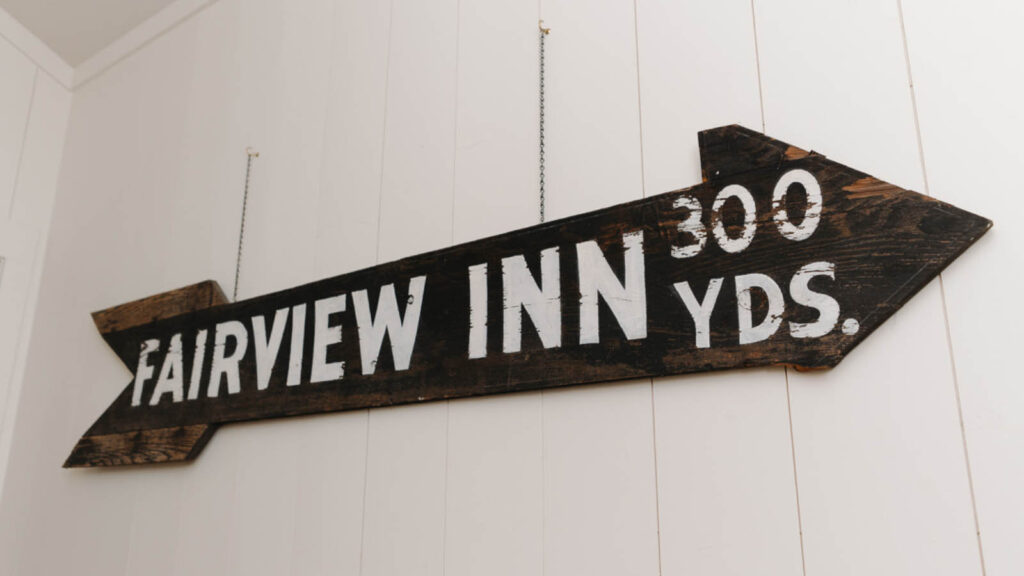 Antique wooden arrow sign reading Fairview Inn 300 yds